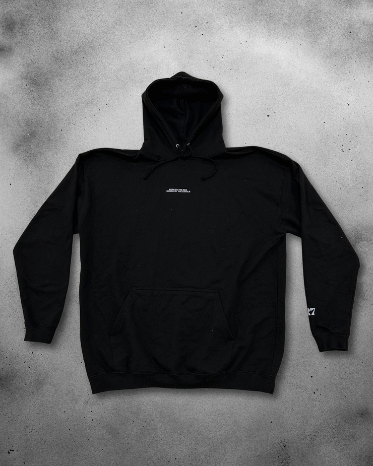 Black hoodie with a brand logo on a gray concrete surface