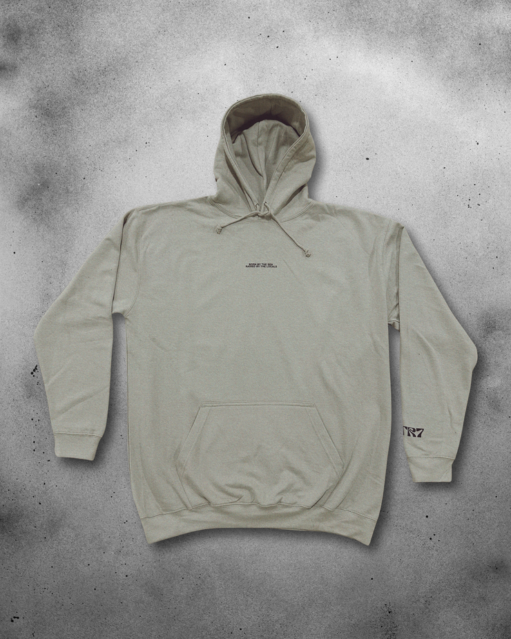 Beige hoodie with branding on a textured gray background