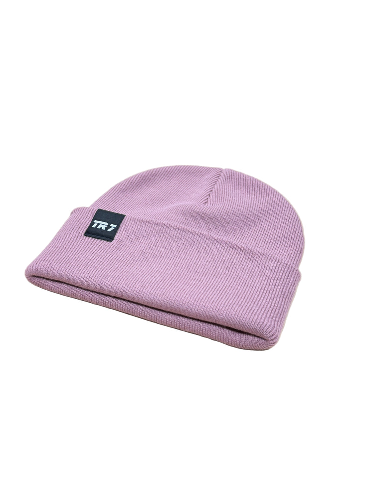 Purple beanie with a brand logo on a wooden surface