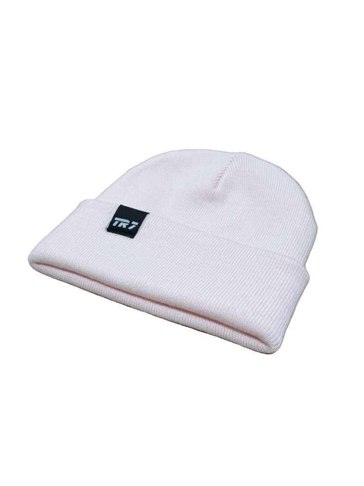 Pink beanie with a logo on a wooden surface